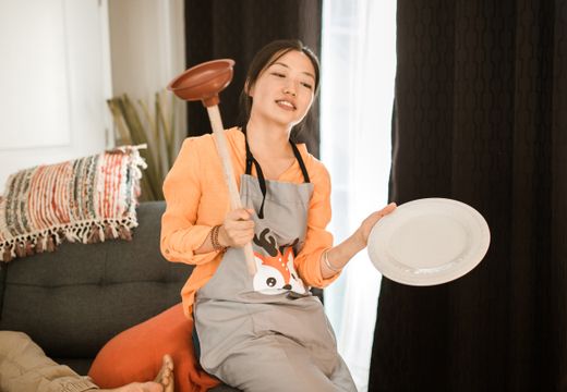 Homeowner holding a plunger, ready for a clogged toilet
