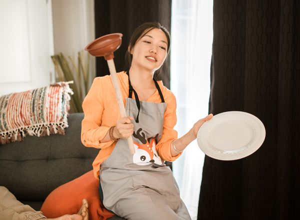 Homeowner holding a plunger, ready for a clogged toilet
