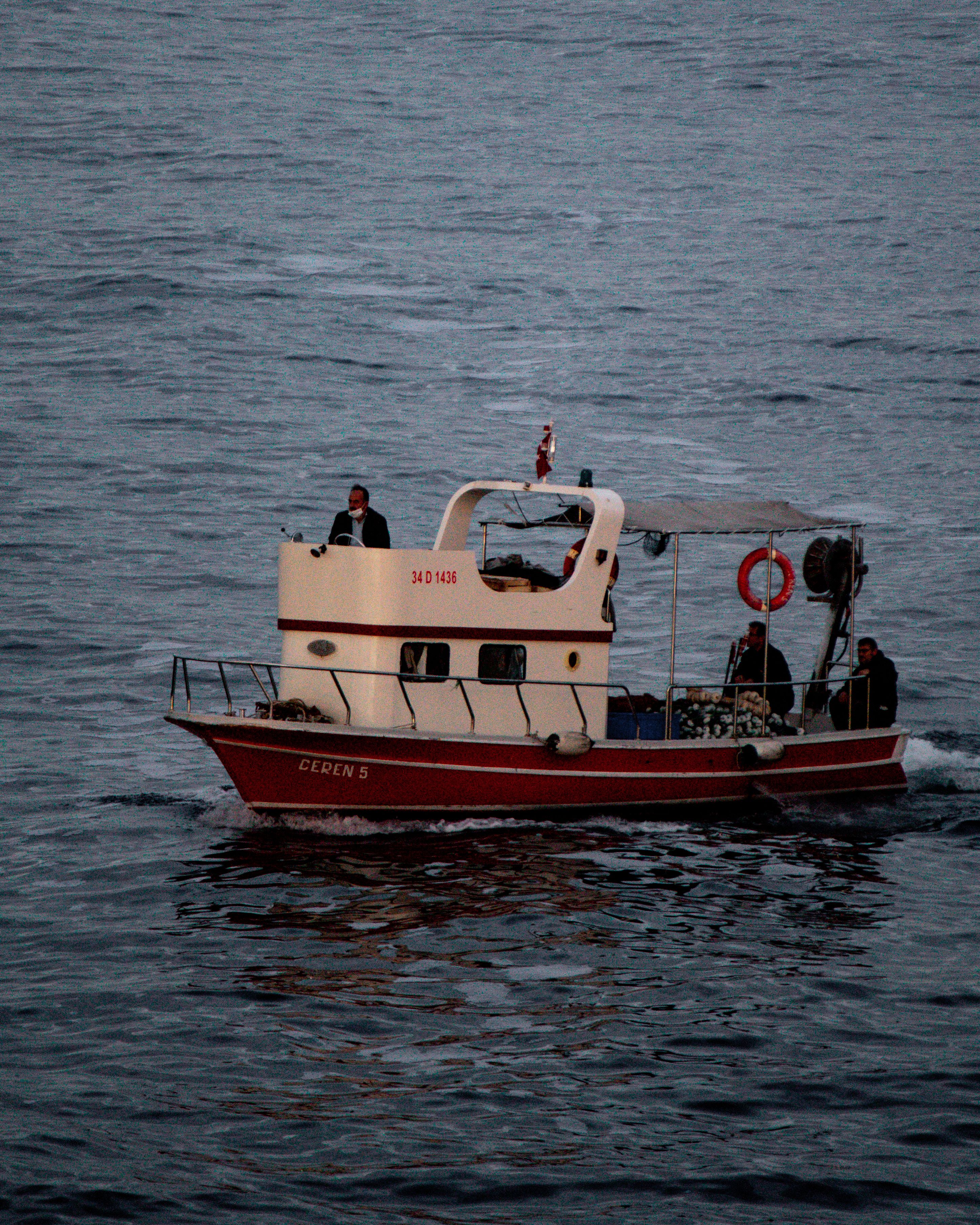 A boat navigates the Bosphorus in Istanbul with passengers aboard, showcasing maritime life.