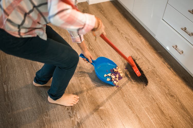 Close-Up Shot Of A Person Sweeping The Trash