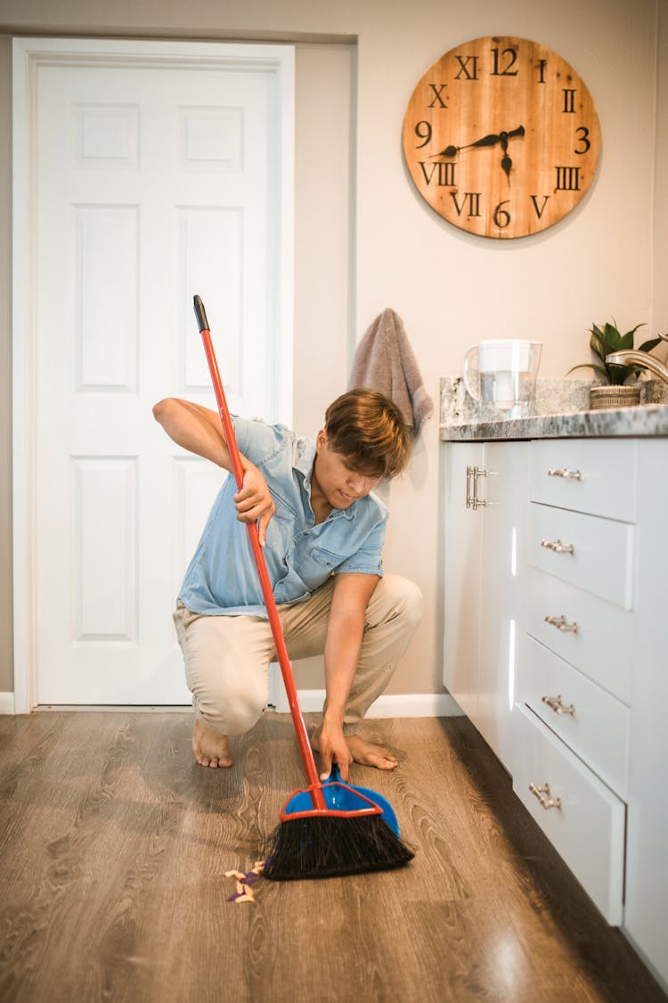 Close-Up Shot Of A Man Sweeping On The Floor