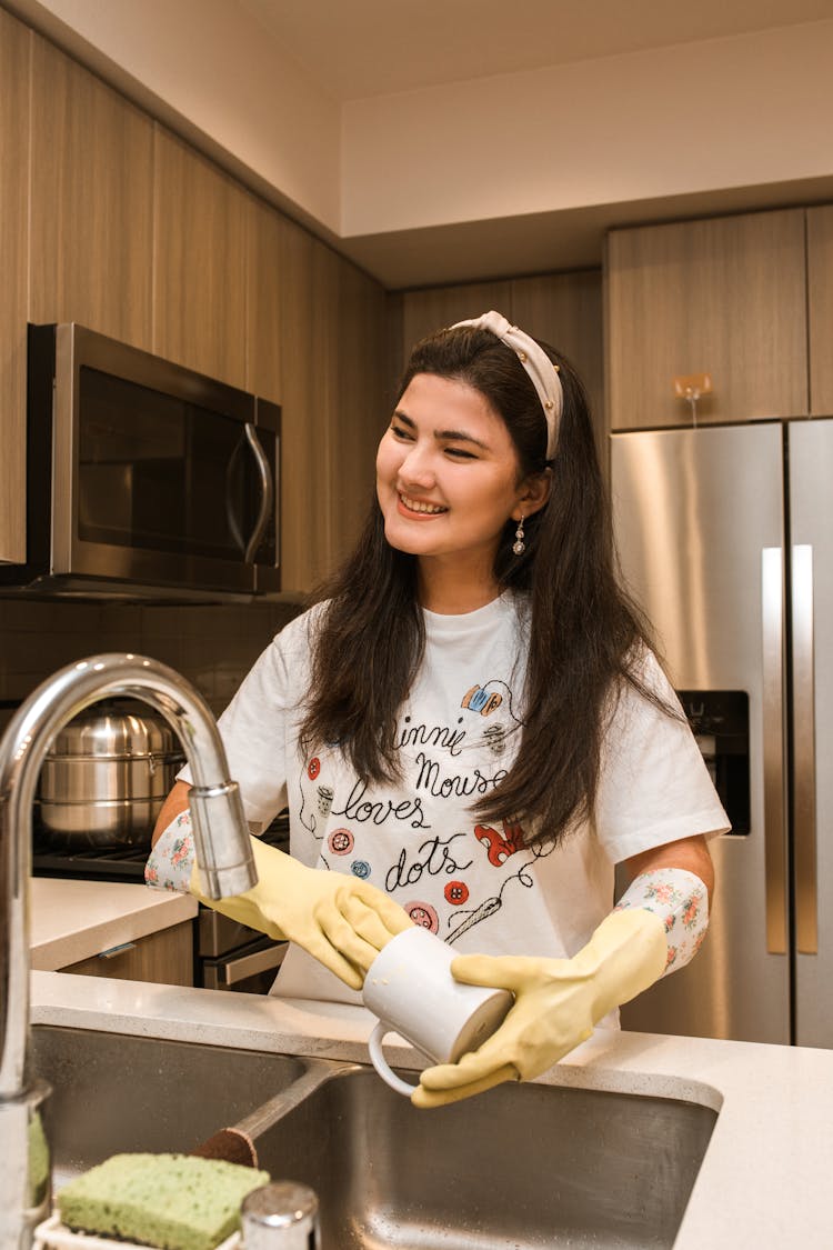 Woman In A White Shirt Washing The Dishes