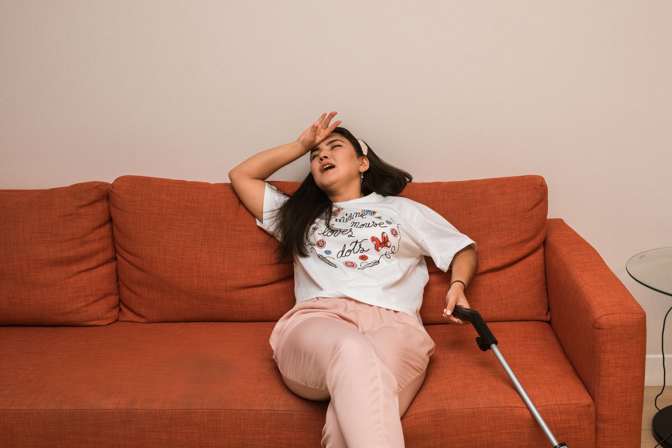 Mulher com expressão de cansaço e fadiga, sentada com as mãos no rosto, representando os sintomas de desnutrição subclínica