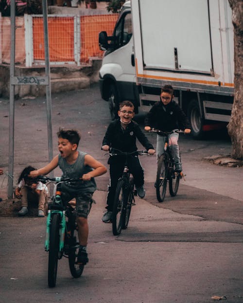 Close-Up Shot of Three Boys Riding Bicycles