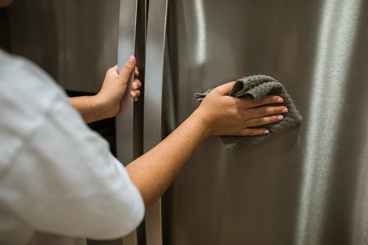 Close-Up Shot Of A Person Cleaning The Refrigerator