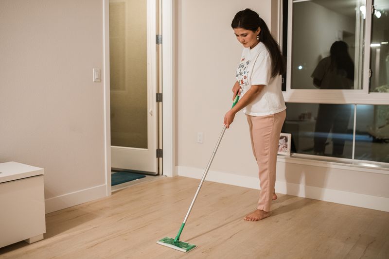 Cleaner mopping a bright living room floor