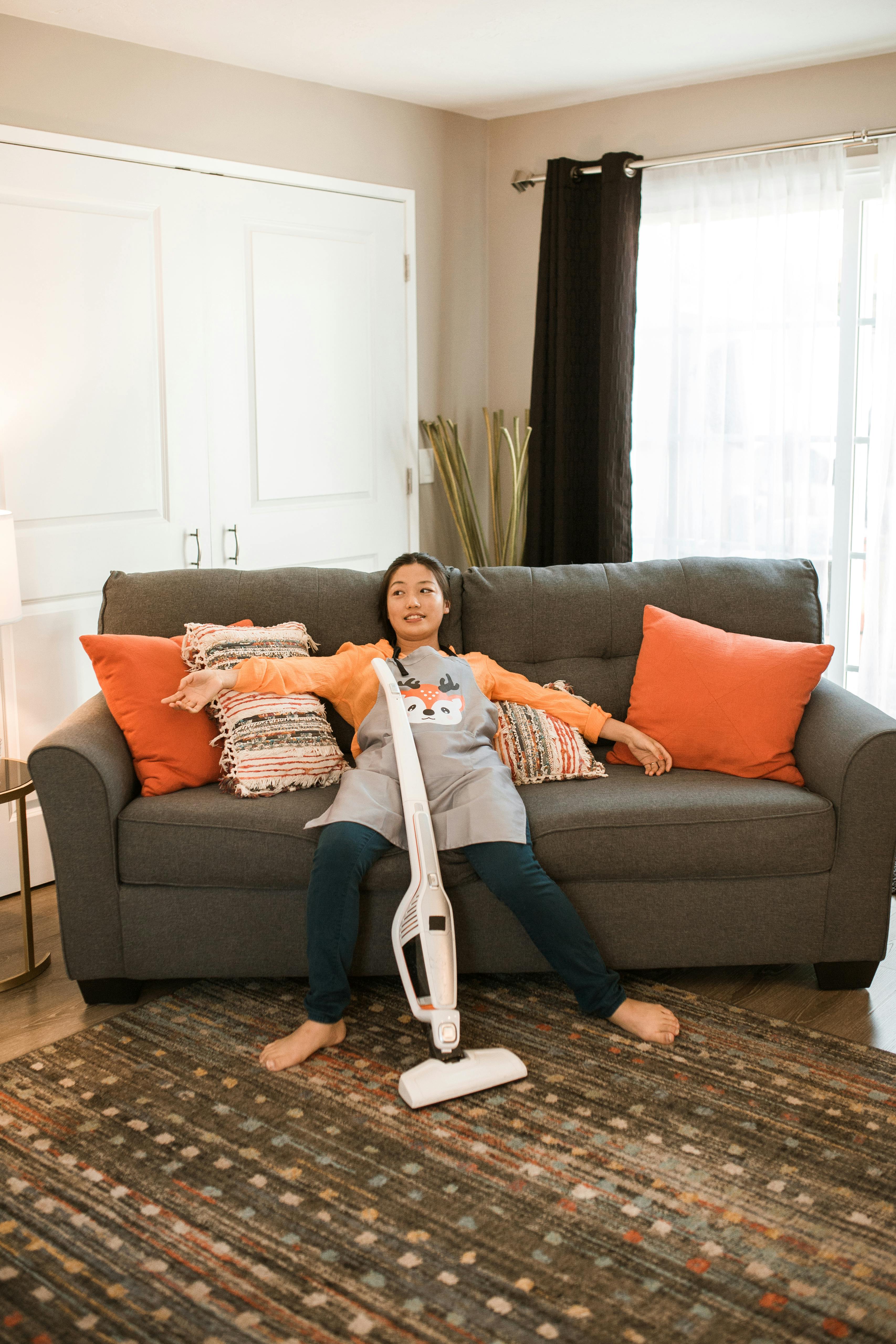 Woman Cleaning Living Room With Vacuum Cleaner Stock Photo