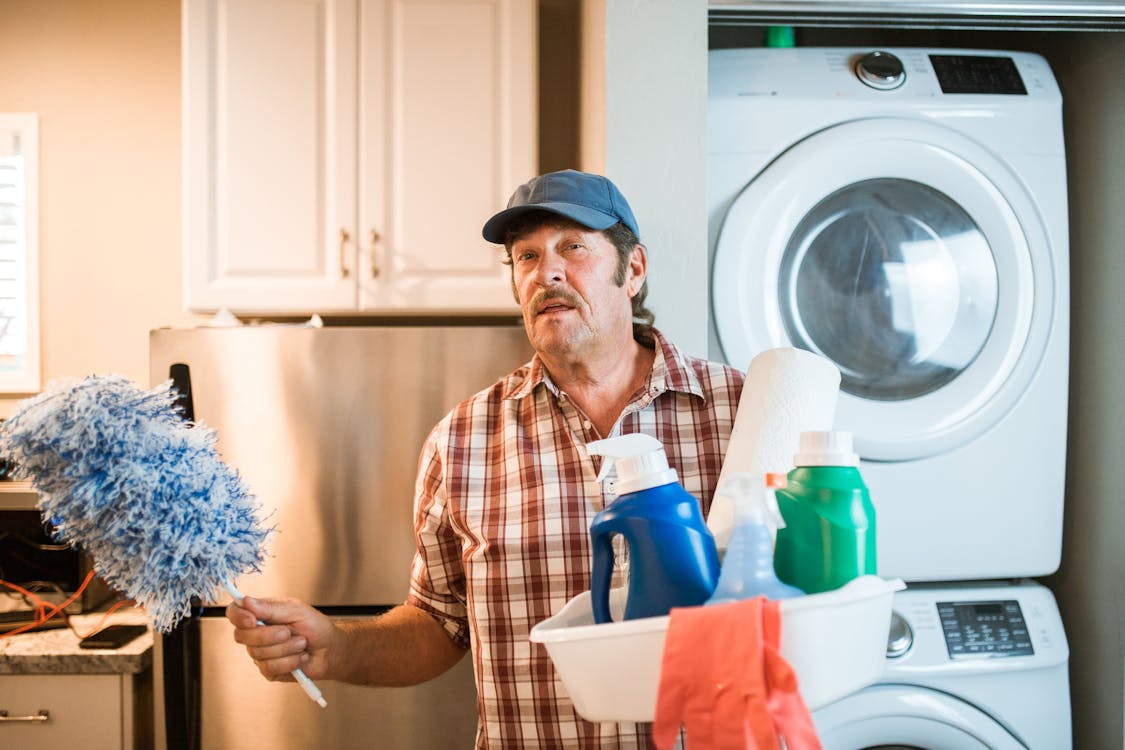 Man in Blue and White Plaid Button Up Shirt Holding White Plastic Container