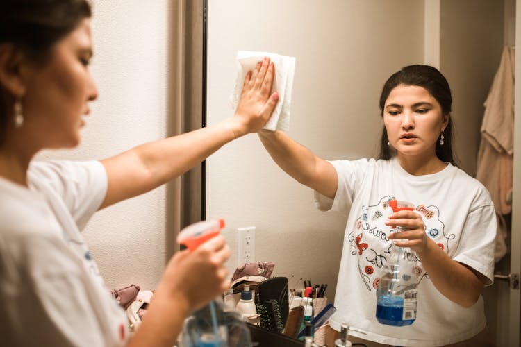 A Woman Wiping A Mirror 