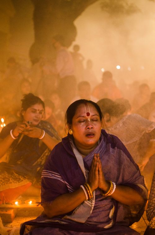 Free Women participate in a traditional prayer ceremony surrounded by candlelight and smoke. Stock Photo