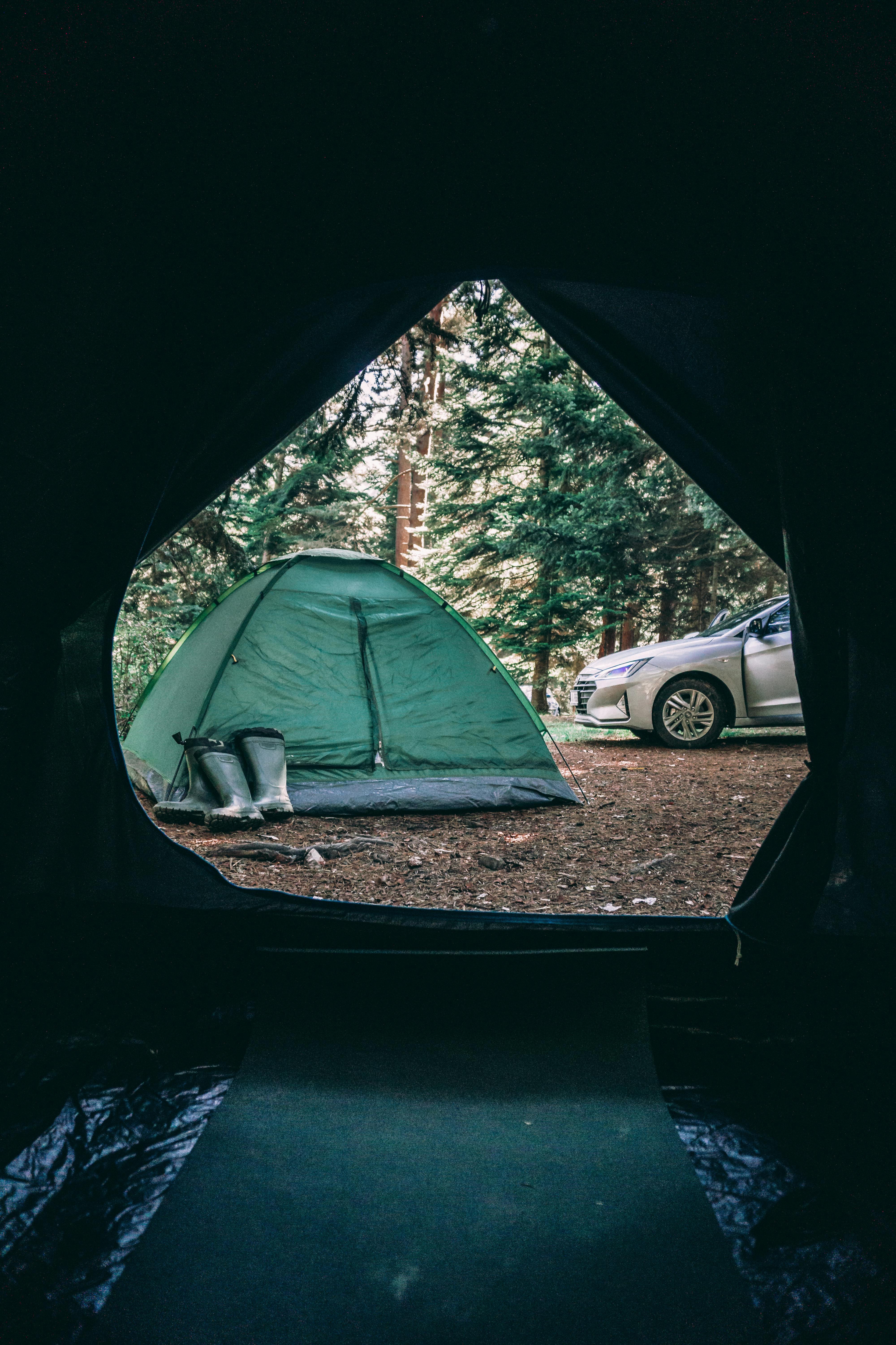 Ultralight camping setup beside a parked car at a quiet forest campsite