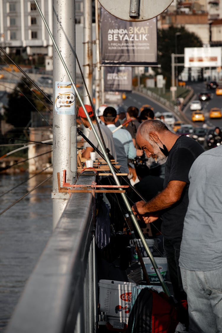 People Fishing At City Bridge