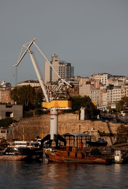 Free A large crane and container ships at Istanbul port under the warm sunset light. Stock Photo