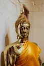 特写：寺庙内披着橙色长袍的金色佛像