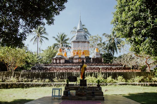 Stunning view of Wat Thai Sarnath Temple surrounded by tropical trees, ideal for travel and cultural exploration.