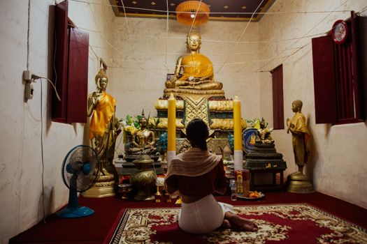 在佛教圣地，一个女人正对着佛像和产品祈祷，场景宁静