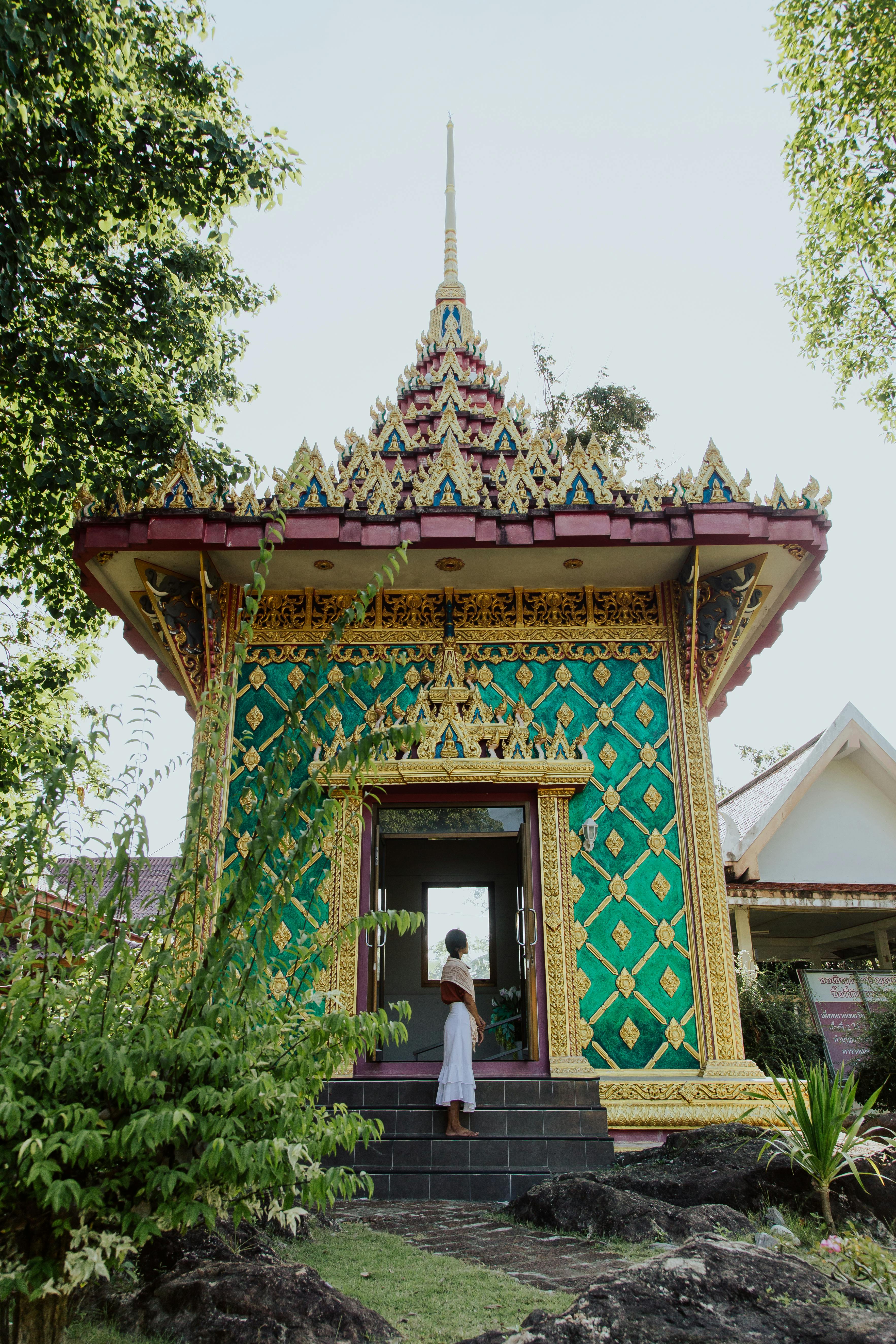 woman standing by ornamented buddhist shrine