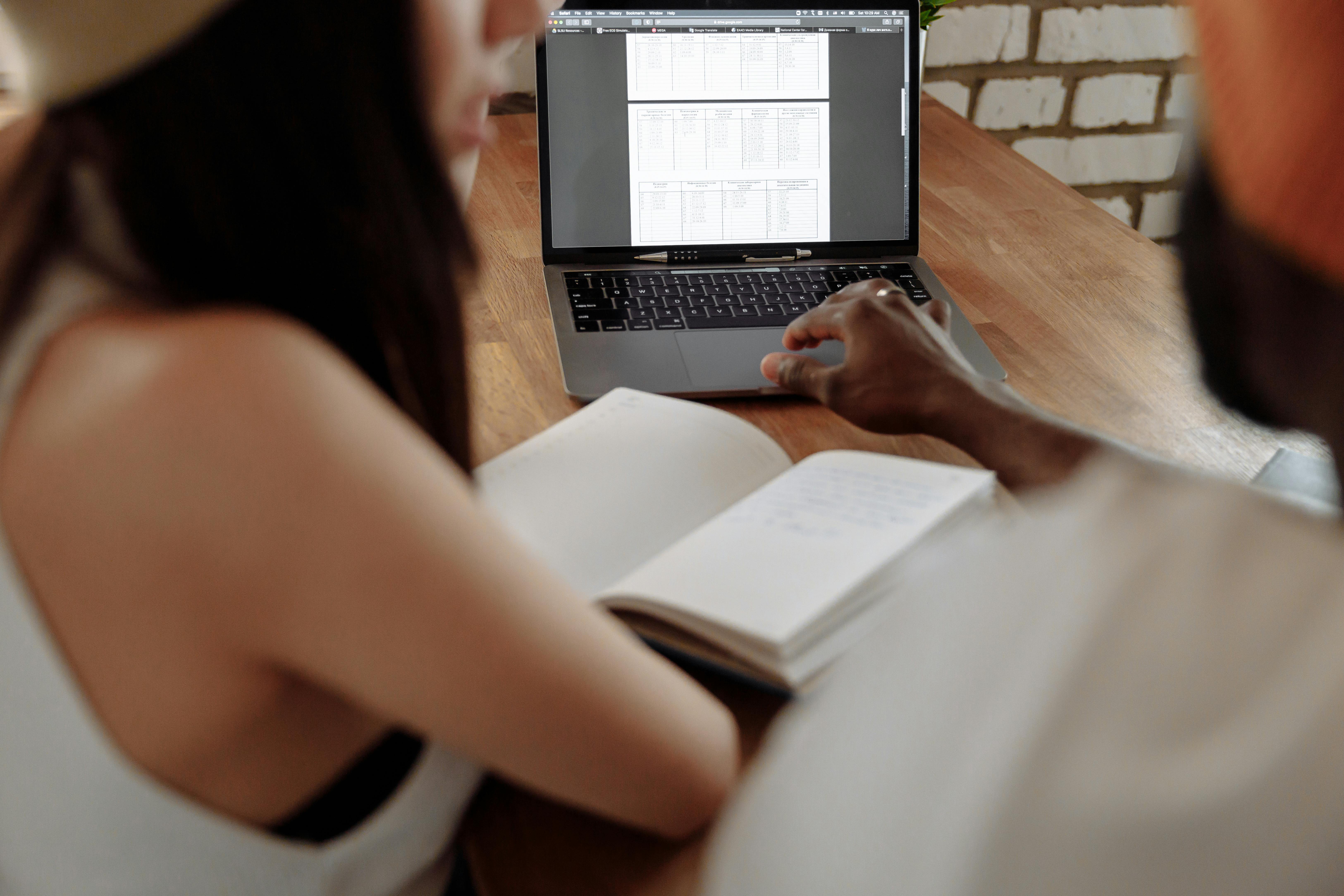 woman in white shirt using macbook pro