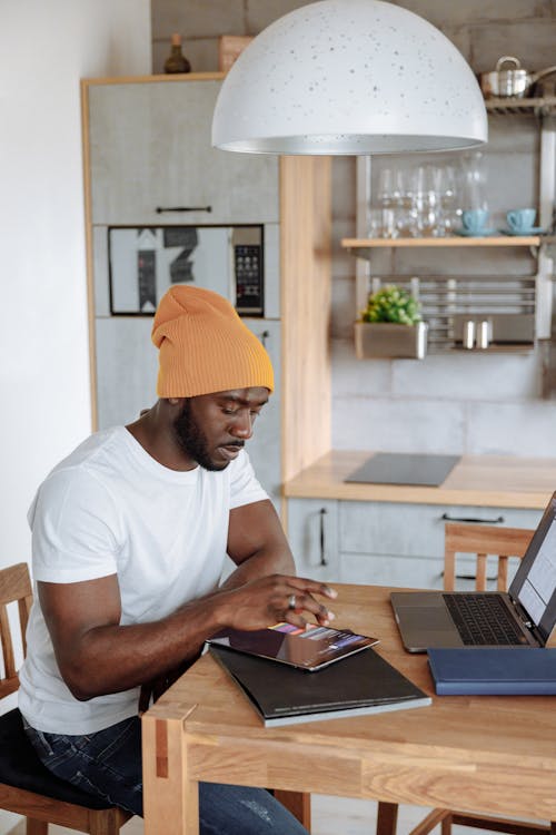 Man in White Crew Neck Shirt Using a Tablet