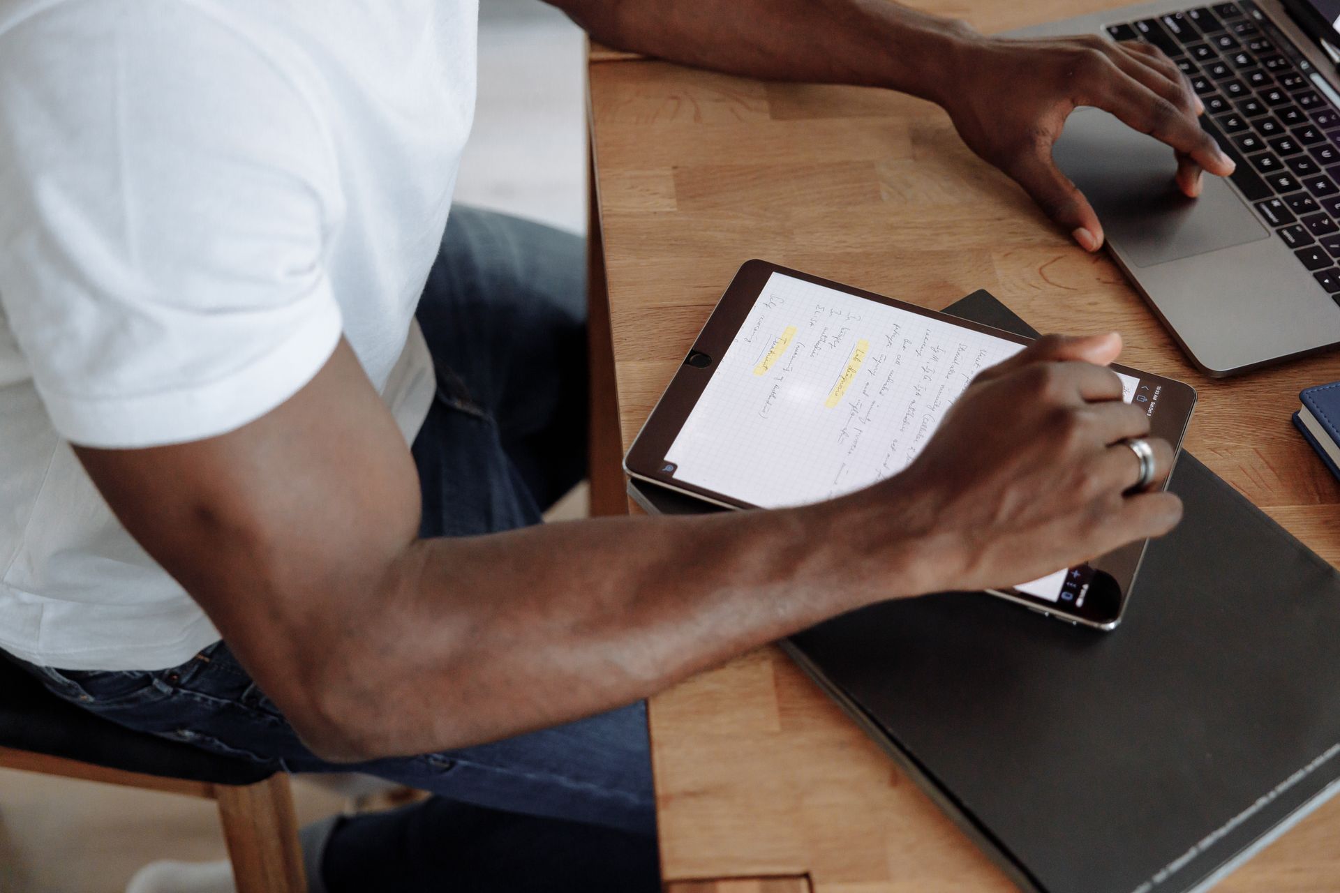 A freelancer working at home with a tablet and laptop, highlighting the modern work-from-home lifestyle.