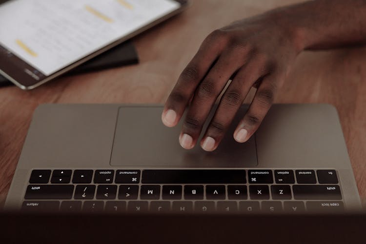 Person's Hand On Silver Laptop Computer