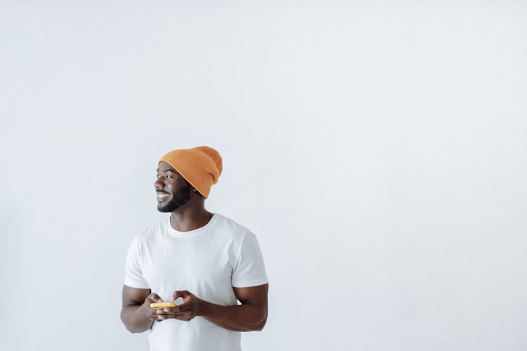 Man In White Shirt Holding A Cellphone While Smiling