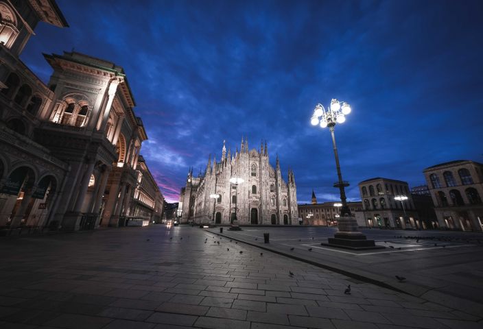 Exterior of old city street with classic buildings and pavement under flashlight at night