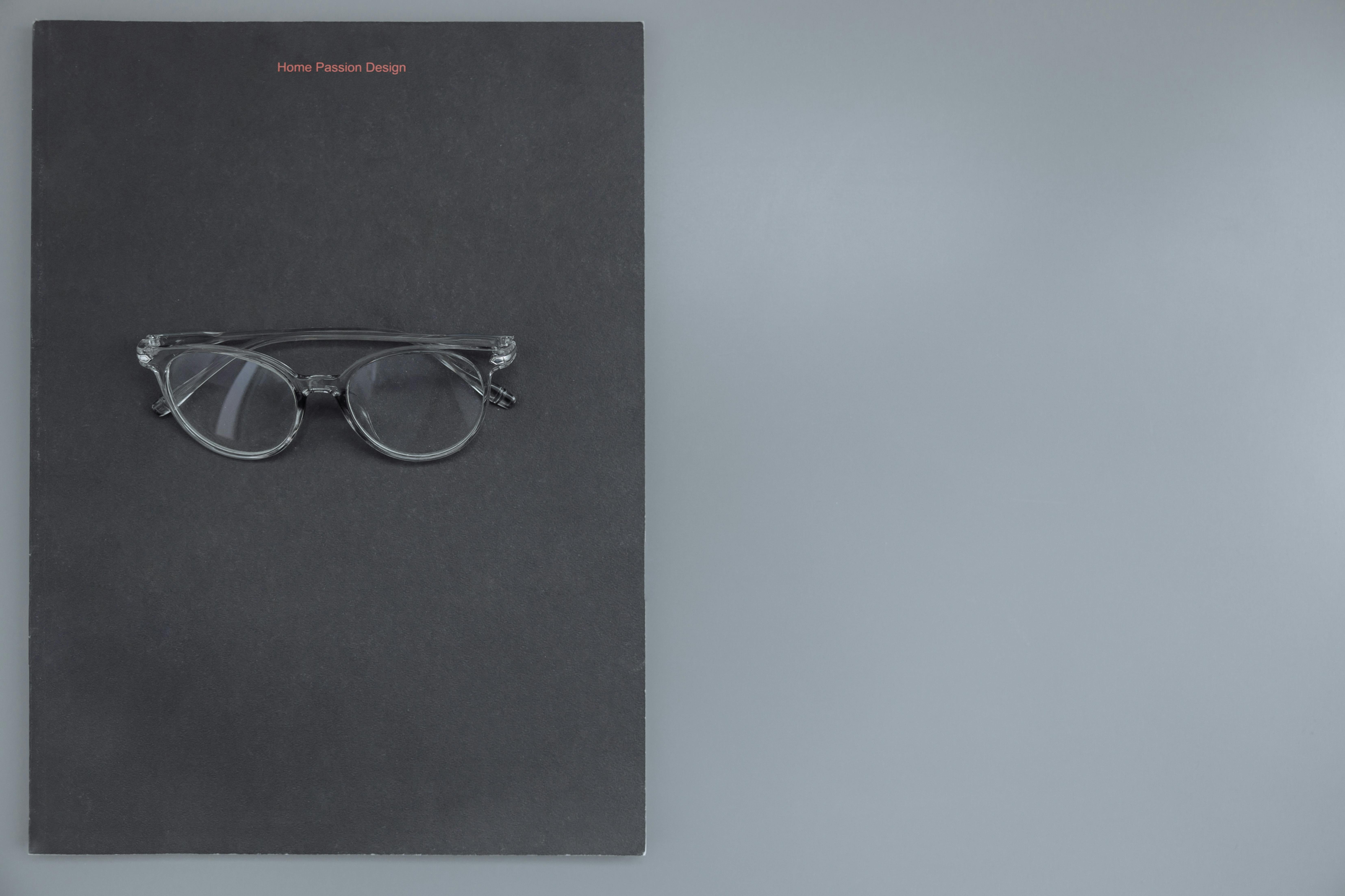 Clear eyeglasses on a black surface, perfect for fashion and design themes.