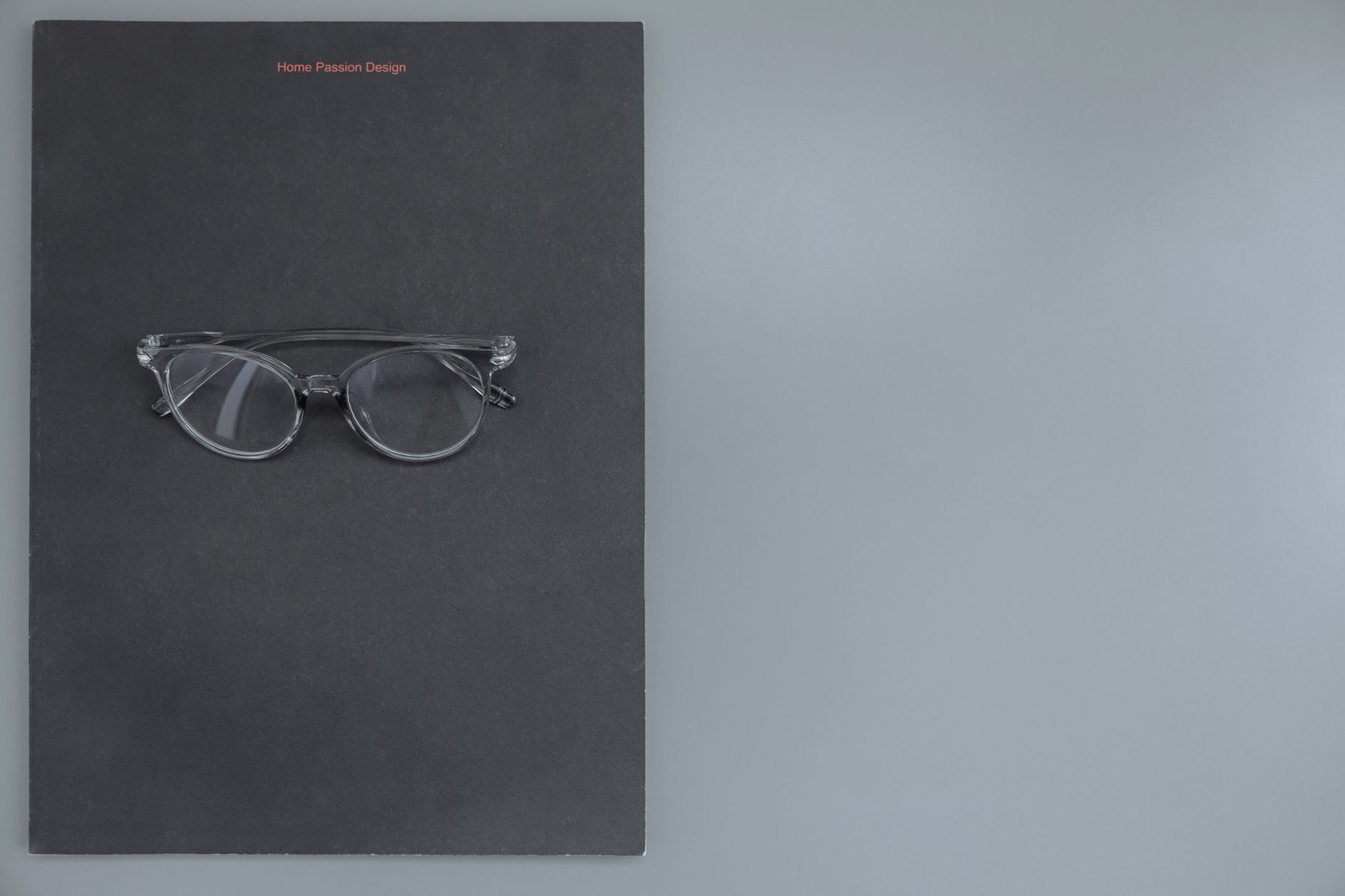 點亮設計品牌顧問 - 網頁設計 logo設計 平面設計 Clear eyeglasses on a black surface, perfect for fashion and design themes.