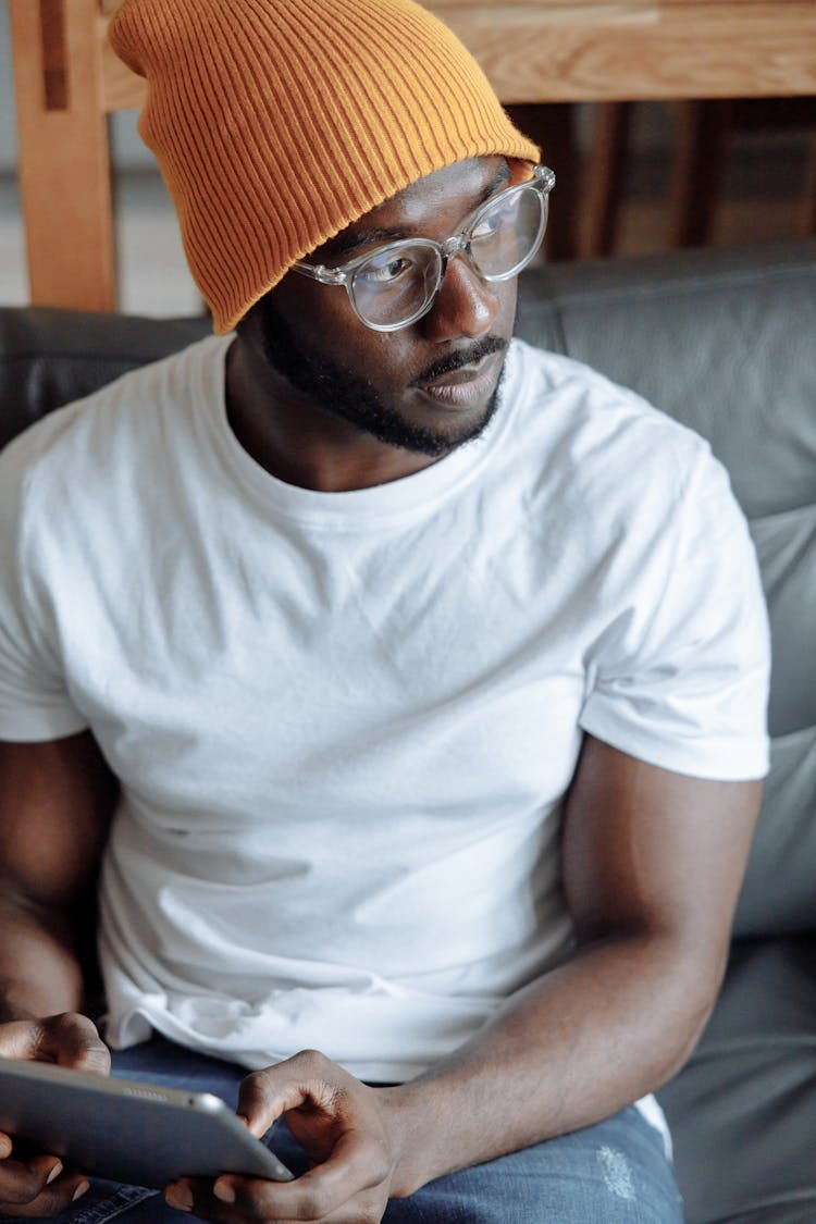  A Young Man In A Yellow Beanie Using A Tablet