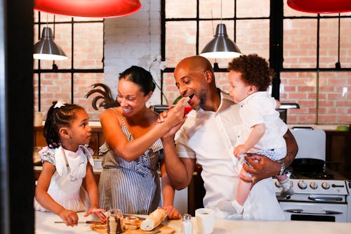 Free A Happy Family Eating Together in a Kitchen Stock Photo