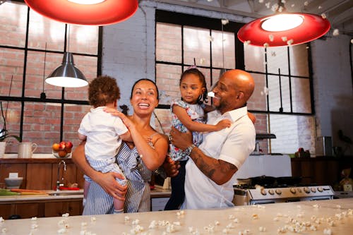 A Couple Carrying their Children in a Kitchen