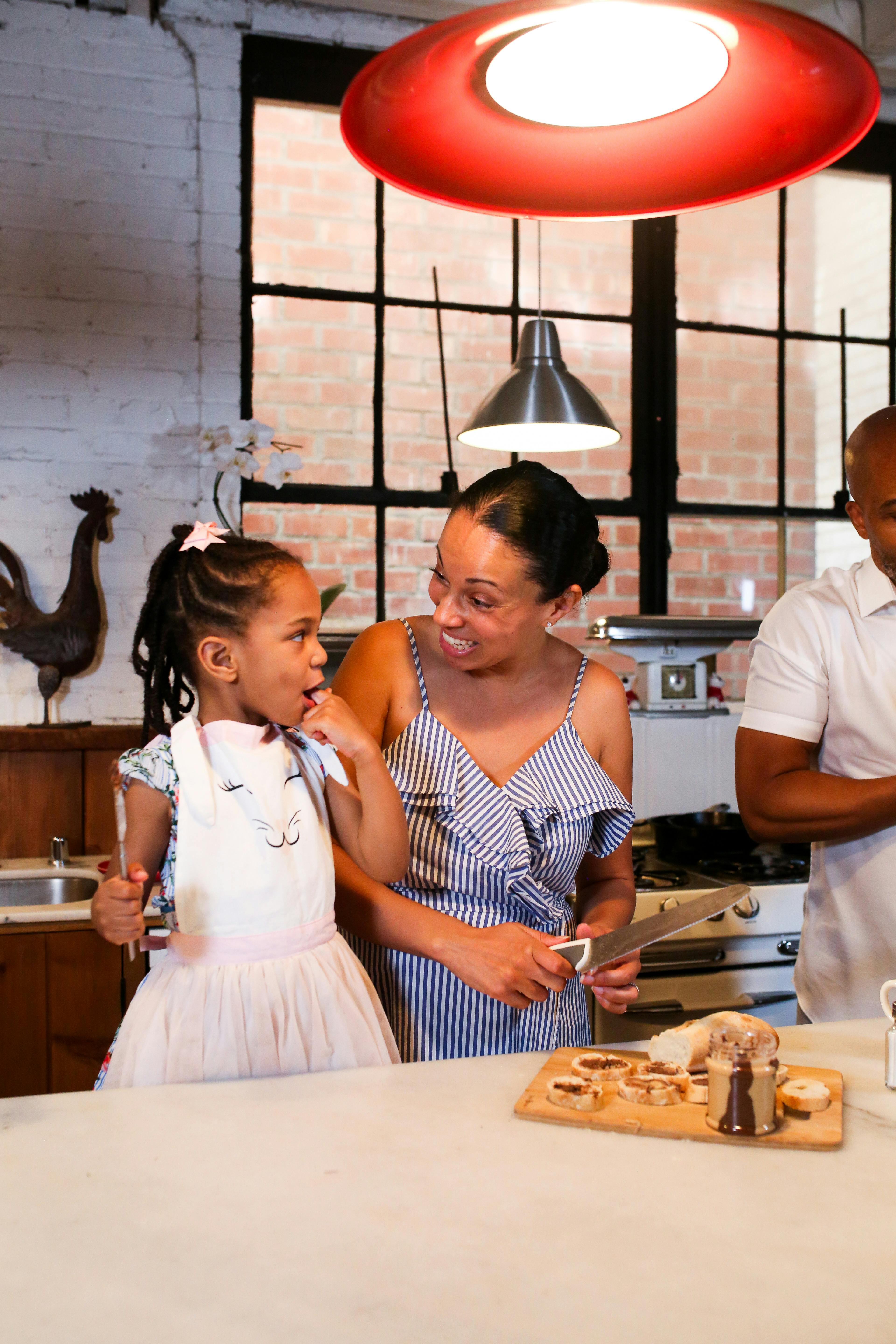 在舒适的厨房里，母女俩正一起准备食物，呈现出一幅欢乐的家庭烹饪场景