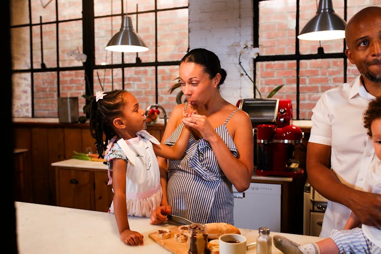 A Family Standing In The Kitchen