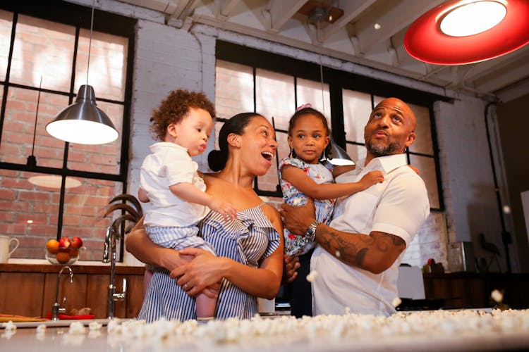 A Happy Family Standing In The Kitchen