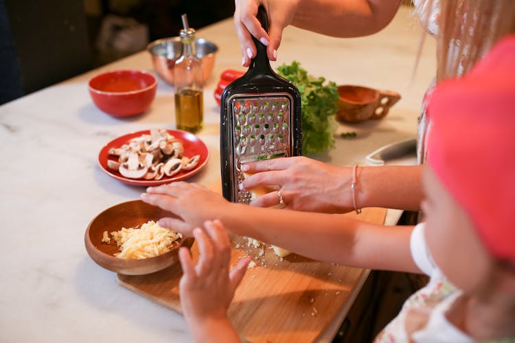 Mother And Daughter Preparing Food On Kitchen Counter