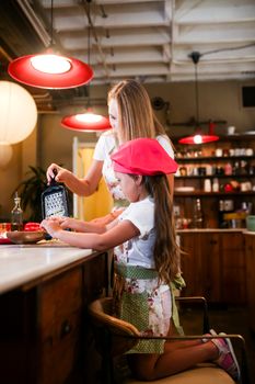 Mother and daughter share quality time cooking in a cozy kitchen.