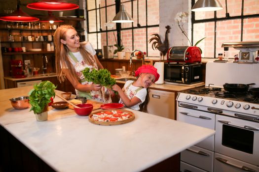 Mother and daughter enjoying quality time cooking in a cozy kitchen.