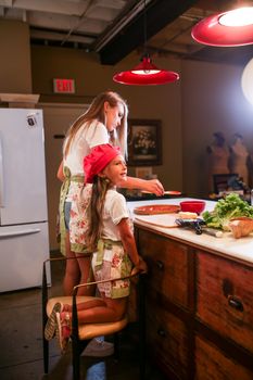 Mother and daughter enjoying a cooking session together, promoting family bonding.