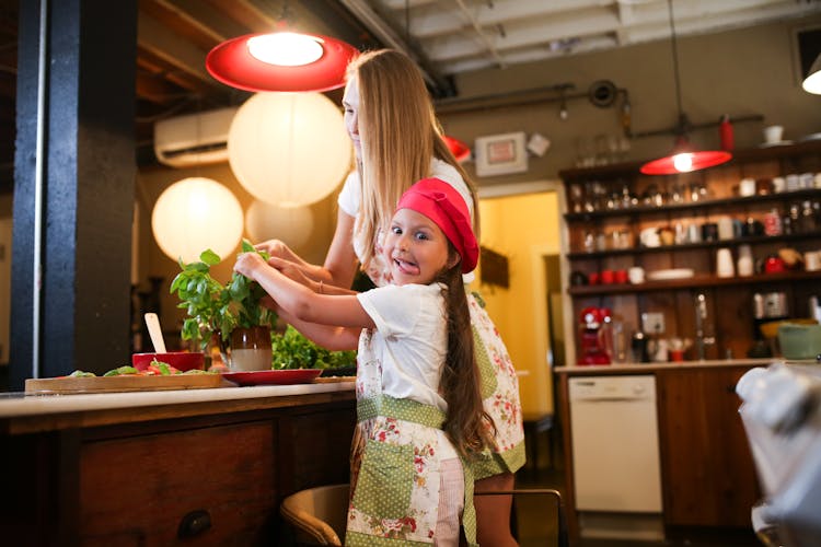 Little Girl Having Fun Preparing Food With Her Mother On Kitchen Counter