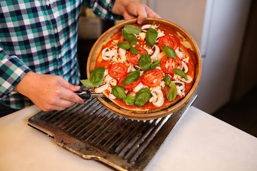 A delicious homemade pizza topped with fresh basil, tomatoes, and mushrooms, ready for baking.