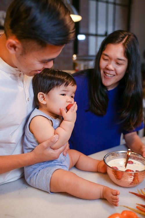 A Baby Boy Eating a Strawberry