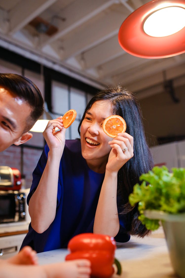 Woman In Blue Top Holding Sliced Oranges