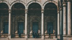 Arched passage at ancient mosque yard in sunlight