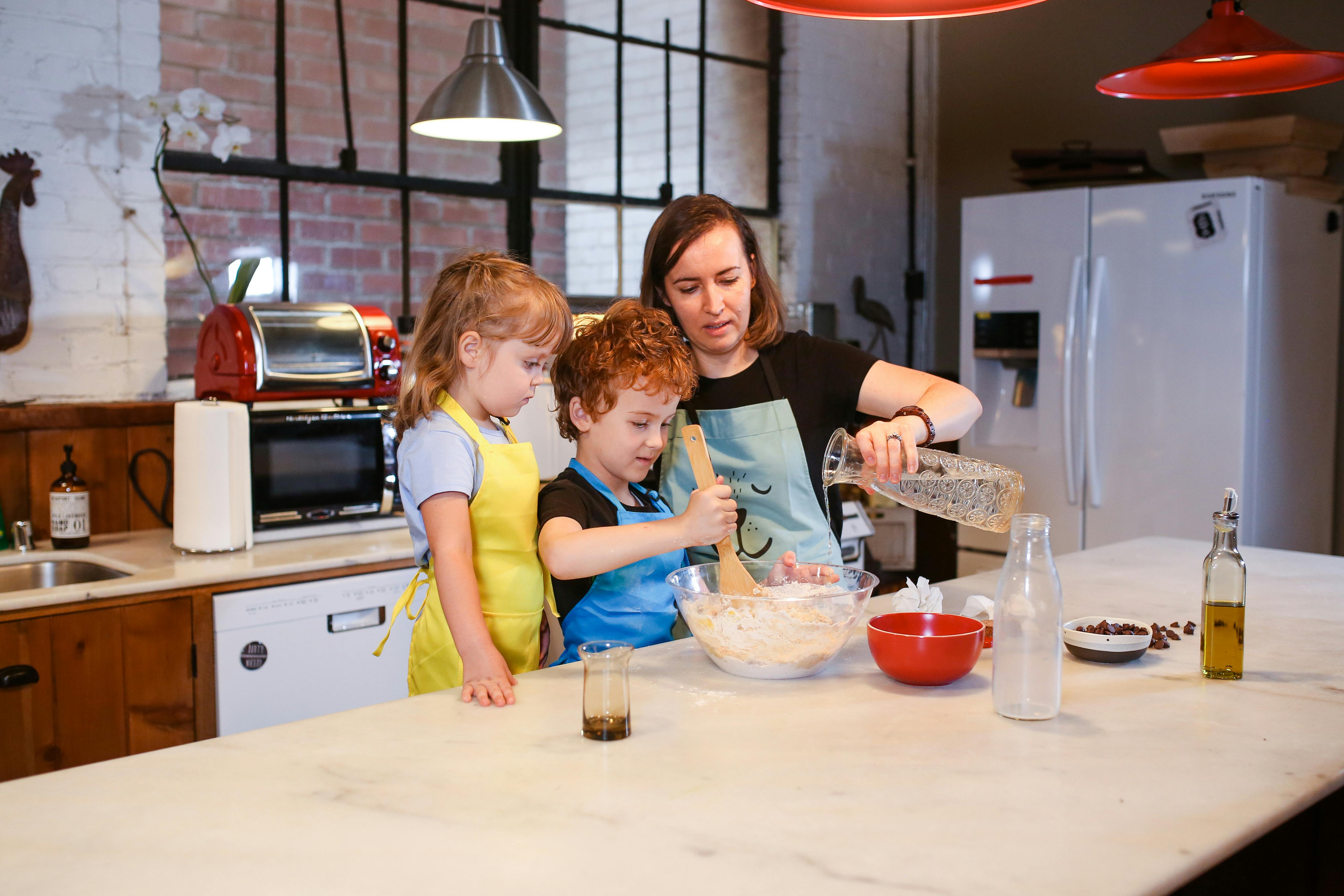 a mom cooking with her kids in a kitchen