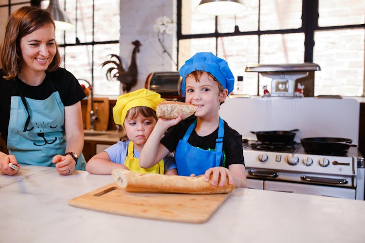 A Boy In A Chef Hat Eating Bread