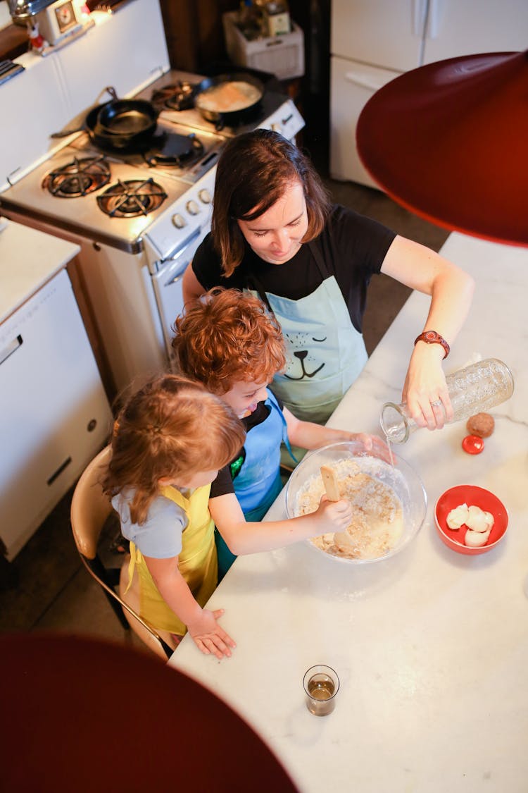 Top View Of A Mom Baking With Her Kids In A Kitchen