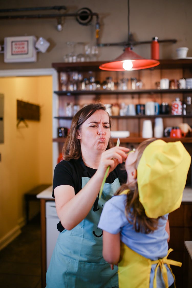 A Woman Pouting Her Lips In Front Of A Child