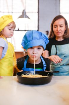 儿童和成人在厨房一起做饭，享受并学习