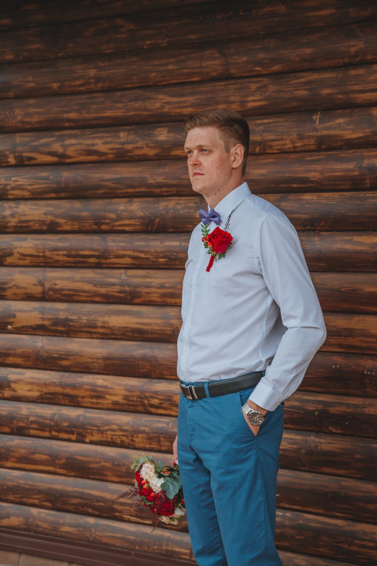 Stylish Man Standing Near Wooden Wall During Wedding